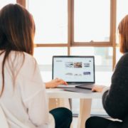 two women around a computer working on website design features